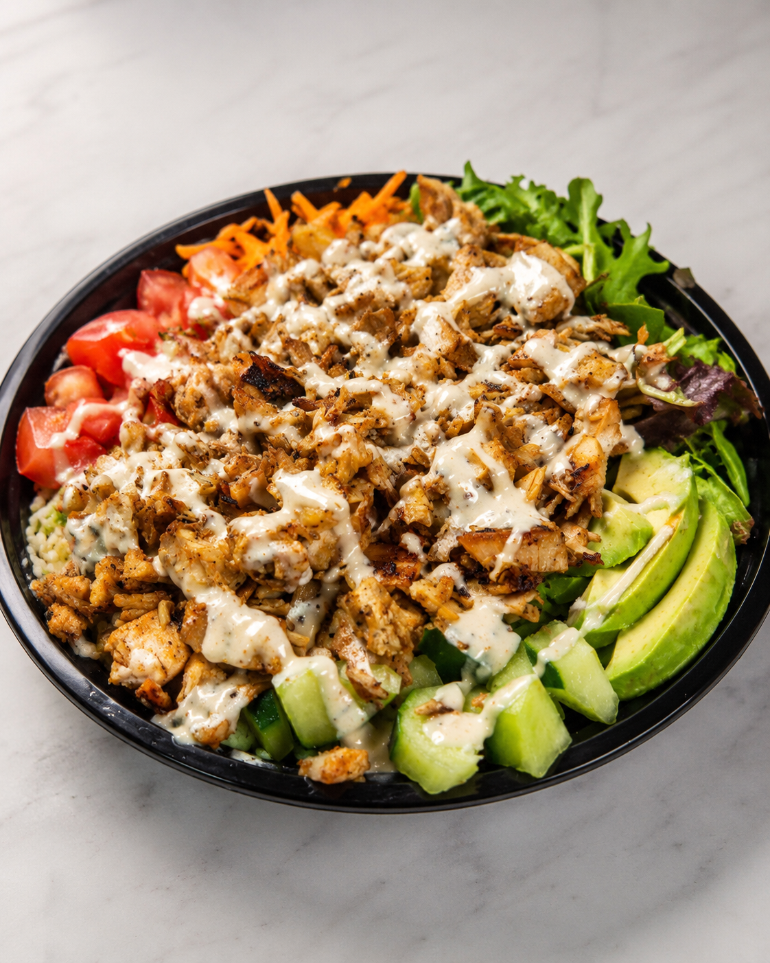 Peri-peri chicken bowl with grilled chicken, rice, fresh greens, cucumber, tomato, carrot, avocado, and sauce